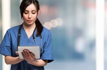 Portrait of a nurse using a digital tablet. Large copy-space